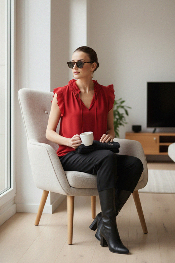 Seated Fashion, Relaxed Pose, Designer Outfit, Elegant Sitting, Luxury Style, Fashion Editorial, Modern Aesthetic, Timeless Look, Chic Comfort, Women’s Apparel, Red Blouse Look, Sophisticated Mood, Polished Style