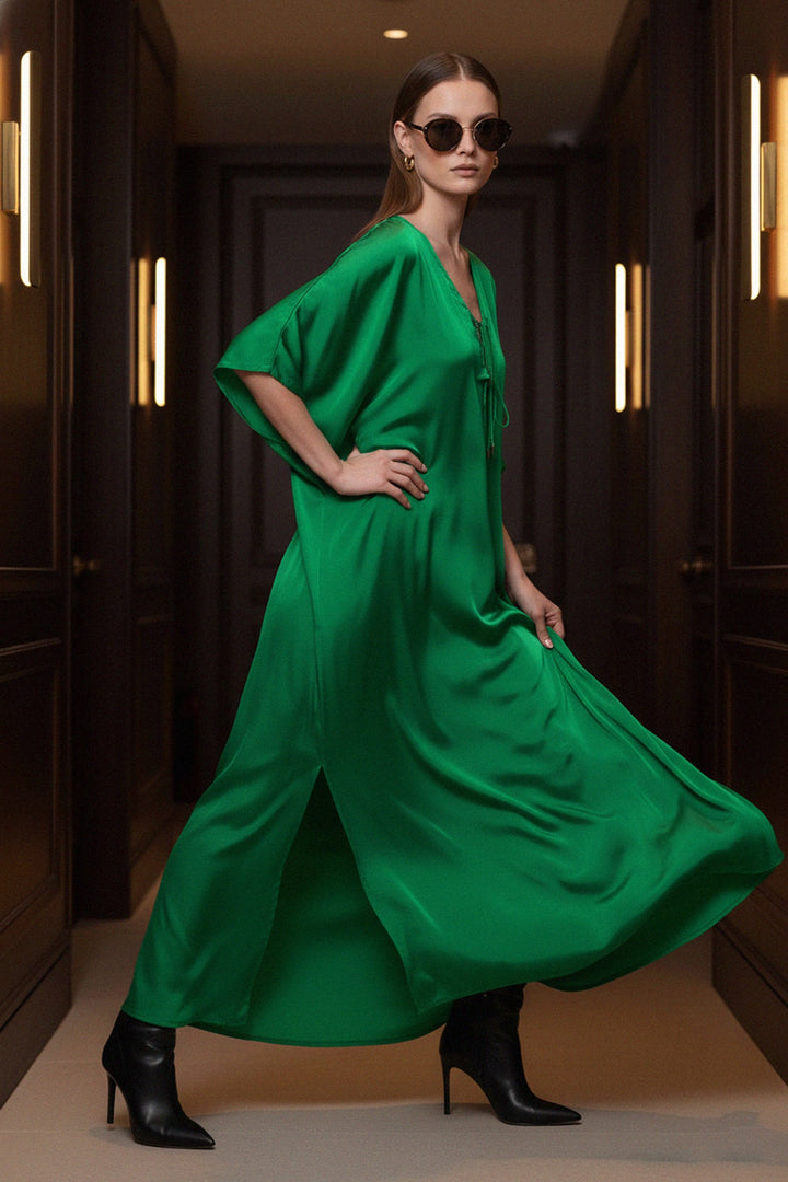 fashion-model, green-silk-dress, sitting-pose, Shahida-Parides, luxury-sofa, vacation-vibes, chic-look, elegant-kaftan, stylish-outfit, modern-dress, resort-style, green-fashion, relaxed-elegance