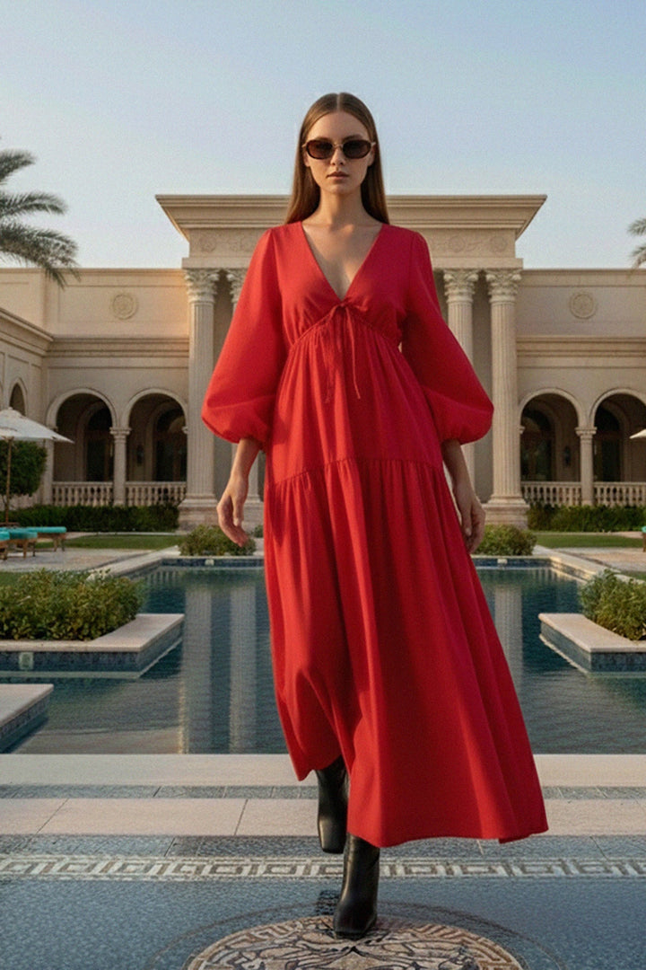 red puff sleeve maxi dress, shahida parides red dress, luxury resort fashion, elegant walking pose, stylish black boots outfit, designer red maxi dress, chic vacation outfit, flowy red resort dress, glamorous walking fashion, sophisticated red gown